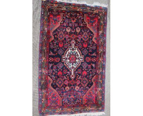 A Persian tribal rug with white central medallion on a blue floral figured ground, 66" x 39" approx