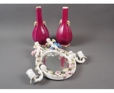 A pair of purple glazed faceted sprinkler bottle vases with lion mask handles, 10 1/2" high, and an oval porcelain mirror wit