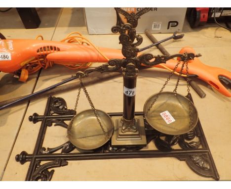 Decorative cast iron wall plaque and a pair of brass balance scales