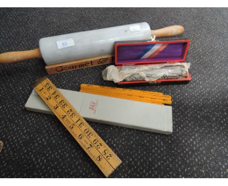 A marble rolling pin, harmonica, slide rule and vintage rule