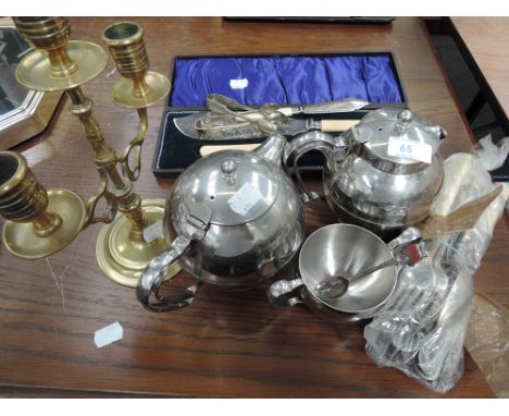 A selection of flatware, brass candlestick, and platedware
