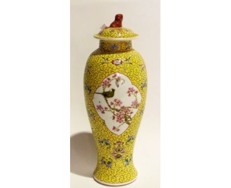 A Chinese yellow ground vase with cover, cherry blossom and bird in cartouche either side, with lion finial, 33cm high 