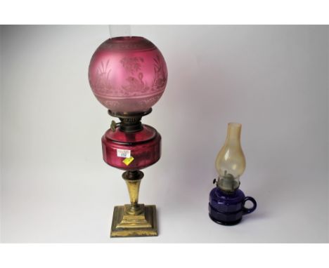 Cranberry glass Duplex oil lamp on brass column with etched shade and decorated with swans and blue glass handheld oil lamp