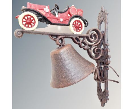 A cast iron bell on vintage car wall bracket.