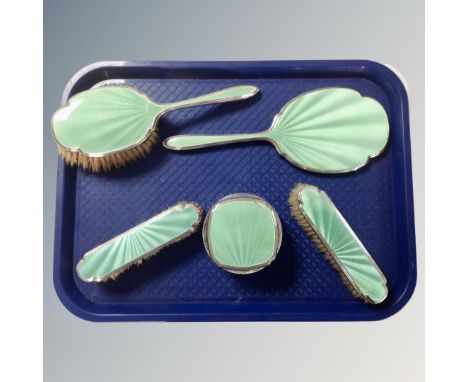 A five-piece silver and green guilloche enamel dressing table set.