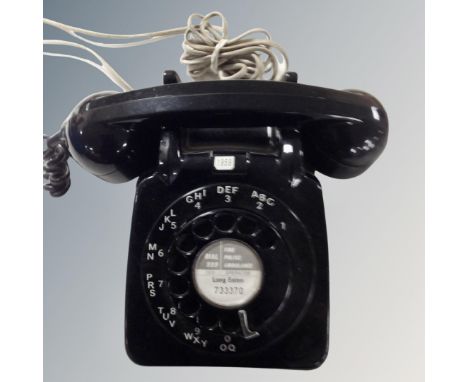 A vintage black dial telephone with plug insert.