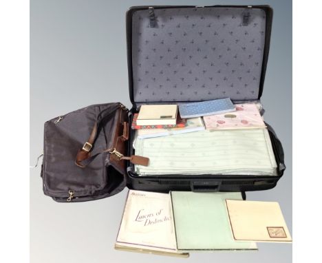 A Delsey hard shell luggage case containing vintage linens, together with a suit carrier.