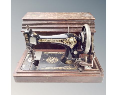 A vintage Singer hand sewing machine in case.