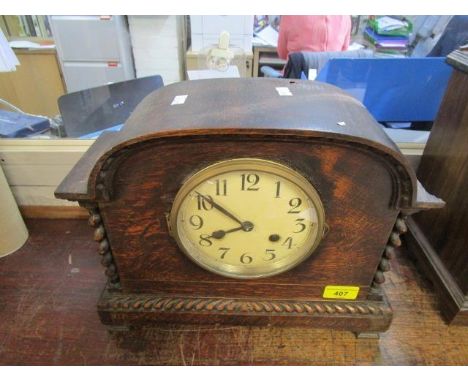 A 1930s oak cased mantle clock, with open barley twist columns, white painted dial with Arabic numerals 