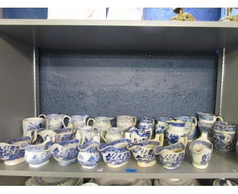 A collection of 19th century blue and white jugs, mugs and sauceboats to include one decorated with the Royal Coat of Arms un