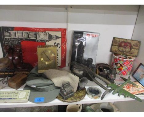 A vintage lot to include military caps, commemorative items, a scrapbook of ephemera, a brass mantle clock, bookends, a leath