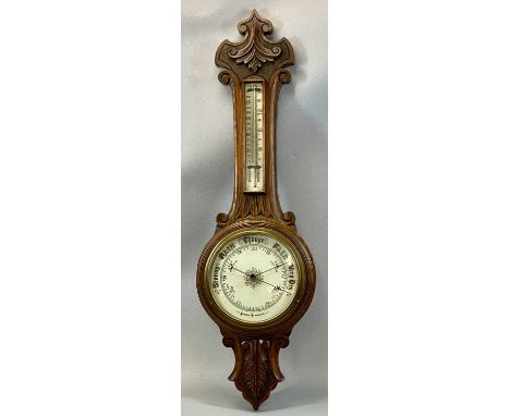 EDWARDIAN OAK CASED ANEROID BAROMETER with carved detail, circular porcelain dial with thermometer, 90cms (h)Provenance: priv