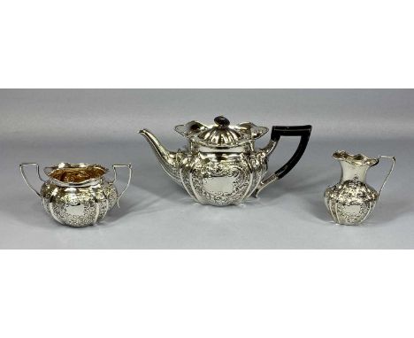 VICTORIAN/EDWARDIAN SILVER THREE PIECE TEA SERVICE, oval form, scroll and floral embossed decoration, the teapot with ebonise