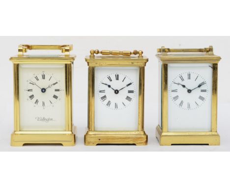 Three 20th century brass and four glass corniche cased carriage clocks to include a Wellington clock, the white dial with bla