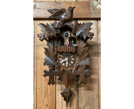 A 20th century carved beech cuckoo clock, the dial with applied Roman numerals, clock 52cm long. 