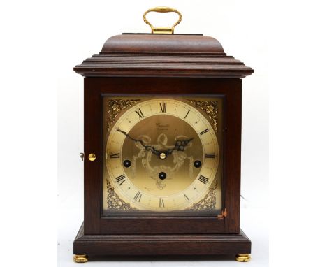 A contemporary Comitti mahogany cased mantle clock, with brass sing handle, the engraved brass dial and brass chapter ring wi