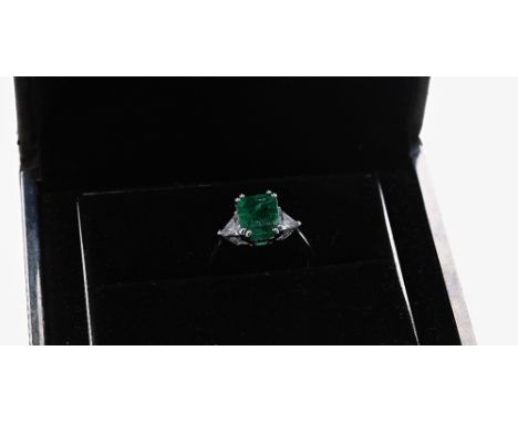 18ct white gold emerald and diamond three stone ring, the emerald 1.67ct approx, with trilliant-cut diamond shoulders, 0.55ct