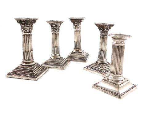 A pair of silver candlesticks, by Garrard and Co., Sheffield 1966, Corinthian column form, beaded borders, on stepped square 