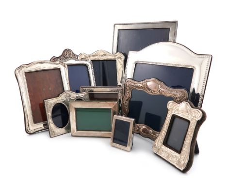 A collection of twelve silver photograph frames, various dates and makers, various shapes, some with foliate and engine-turne