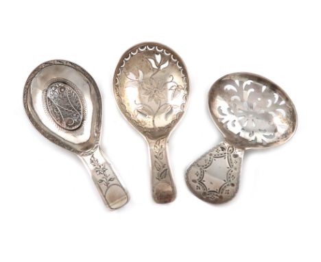 A small collection of three antique silver caddy spoons, all with oval bowls, pierced decoration and engraved handles, one wi
