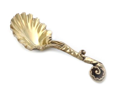 A William IV cast silver-gilt caddy spoon, by Paul Storr, London 1834, shell bowl, foliate scroll handle with a shell motif, 