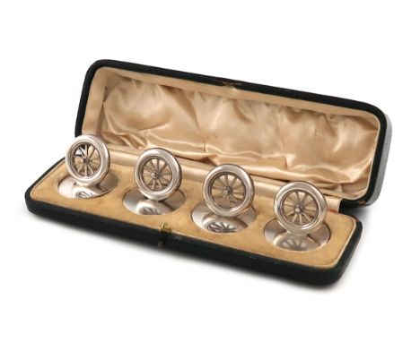 A set of four Edwardian novelty silver menu card holders, by William Hornby, London 1905, modelled as early motor car wheels,