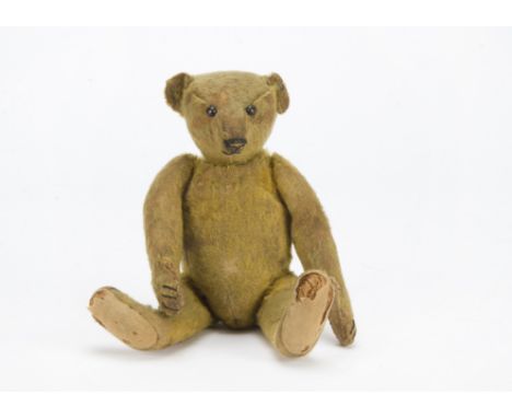 An early Steiff teddy bear, circa 1908, with short golden mohair, black boot button eyes, pronounced muzzle, black stitched n