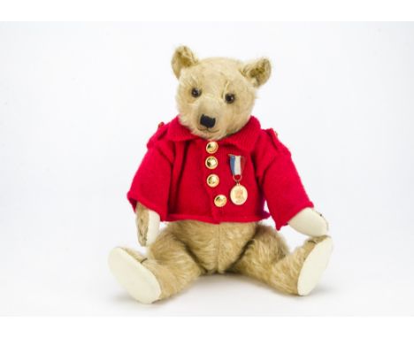 A 1930s British teddy bear, with light golden mohair, replaced glass eyes, pronounced muzzle, swivel head, jointed limbs and 