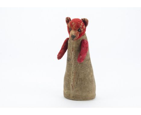 An unusual and rare German teddy bear circa 1910, with red mohair head and arms, black boot button eyes, black stitched shiel