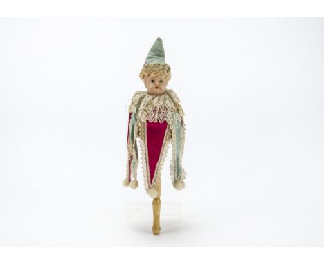 A German celluloid marotte, with blue painted eyes, wooden stick with whistle, revolving body to make music, dressed in origi