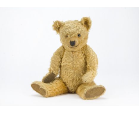 A 1930s Chiltern Hugmee musical teddy bear, with golden mohair, one clear and black glass eye with remains of brown painted b