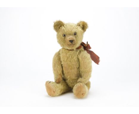 An early British musical teddy bear 1920s, with blonde mohair, clear and black glass eyes with remains of brown painted backs