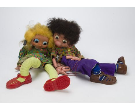 Two large display Pelham Puppet boy and girl, with large heads, plastic eyes with floating pupil, she with blonde synthetic h