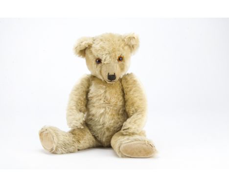 A 1930s Chiltern Hugmee teddy bear, with blonde mohair, orange and black glass eyes, pronounced clipped muzzle, black stitche