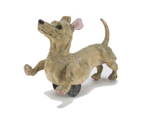 A rare French push-a-long running dachshund automaton, 1920s, flock covered papier-mâché with brown, black and white glass ey