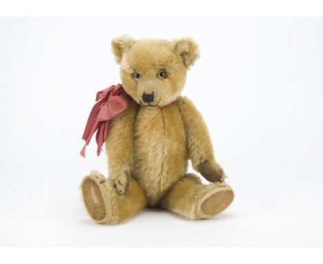 A 1930s Chiltern Hugmee teddy bear, with blonde mohair, clear and black glass eyes with remains of brown painted backs, prono