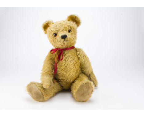 A post-war British teddy bear, possibly Lefray with golden mohair, large orange and black glass eyes, black stitched nose and