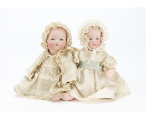 A Gebruder Heubach 6894 character baby, with blue intaglio eyes, closed mouth, composition bent-limbed body and cream silk dr