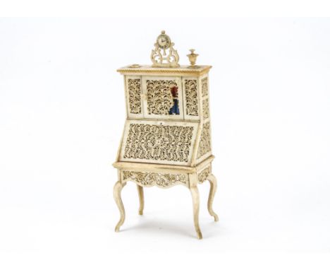 A 19th century dolls’ house bone bureau book case, on cabriole legs, pierced panels, opening to reveal mirrored back and inks