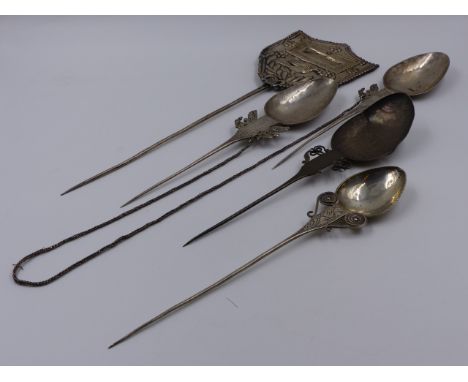 FOUR WHITE METAL DECORATIVE ELONGATED SPOONS TOGETHER WITH A SHIELD SHAPED PLAQUE. APPROXIMATE MEASUREMENT OF SINGLE SPOON 28