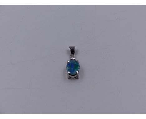 AN OPAL DOUBLET AND DIAMOND PENDANT SET IN 14ct STAMPED WHITE GOLD MOUNT.
