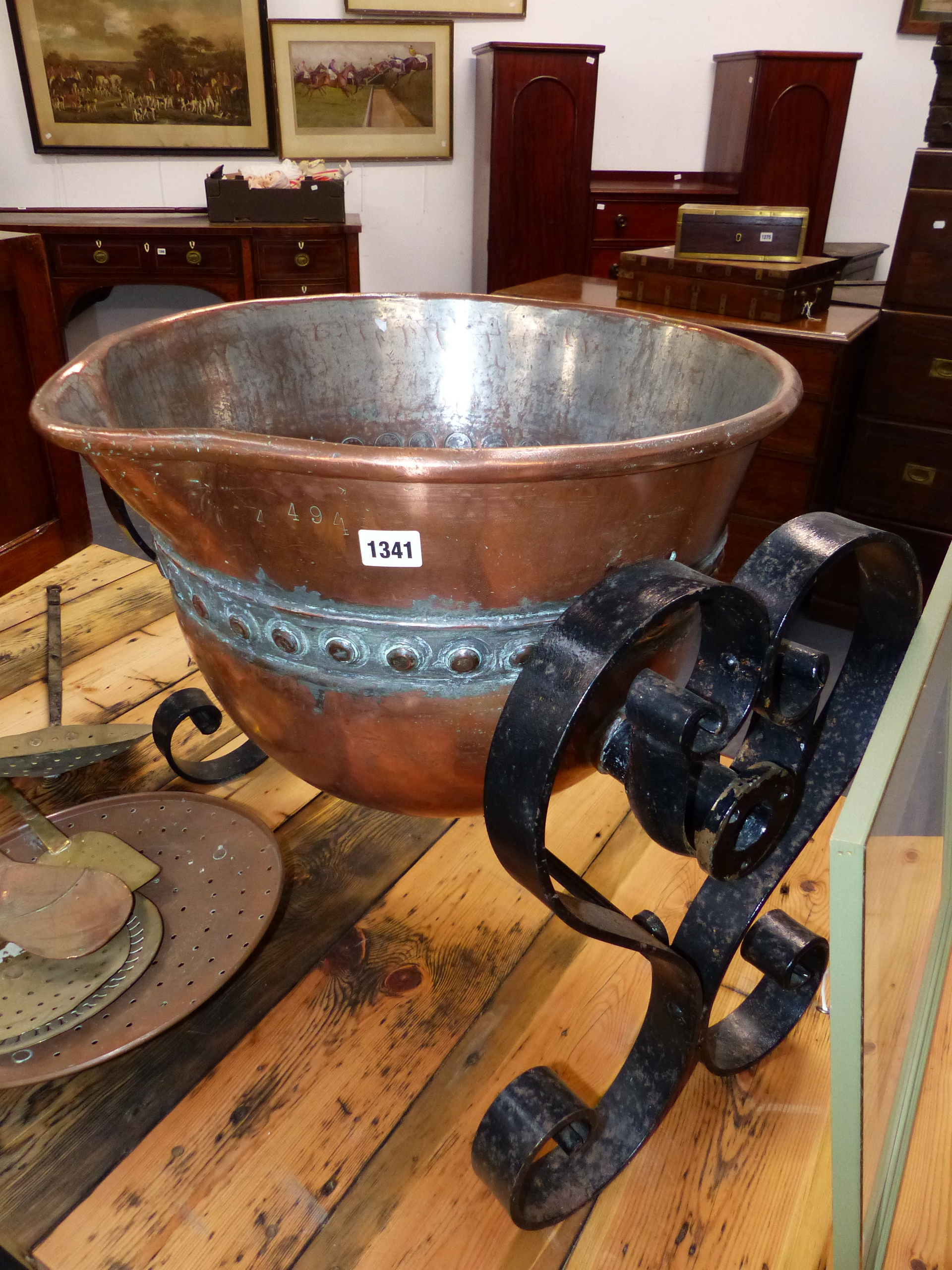 A LARGE COPPER CAULDRON ON WROUGHT IRON STAND.