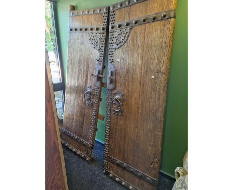 A pair of Chinese iron studded doors, each with ring handles below the lock plate, each. 228 x 78cmsThe ring handles are fixe