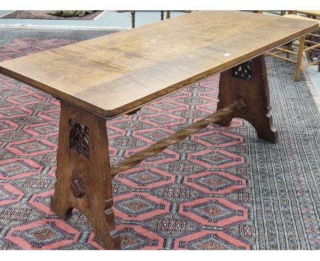 A Liberty's oak table, the rectangular top supported at each narrow end by panel legs pierced and carved with foliate lattice