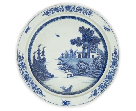 An unusual Chinese European subject blue and white shallow basin, Qianlong period, painted with a man on a rocky outcrop with