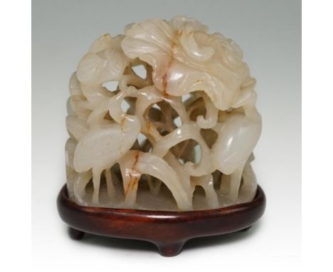 A Chinese pale celadon and russet veined jade ‘egret and lotus’ hat finial, Jin-Yuan dynasty, intricately carved in high reli