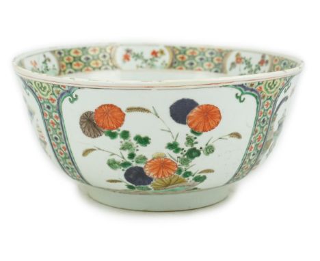 A large Chinese famille verte bowl, Kangxi period (1662-1722), the panelled exterior painted with reserves of Antiques and fl