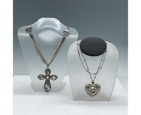 This lot includes two silver-tone pendant necklaces adorned with sparkling rhinestones. The first necklace features a heart-s