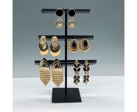 A collection of five pairs of vintage earrings featuring a mix of clip-on and post-back styles. The designs include black ena