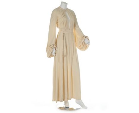 An Ossie Clark ivory moss crepe 'Come Fly With Me' gown, early 1970s, labelled and size 12, wrap-around style with open back,